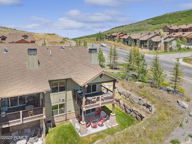 14482 N Buck Horn Trl Unit 50A, Heber City, UT 84032 - rear view of house featuring roof with shingles, stone siding, a patio area, a mountain view, and a residential view