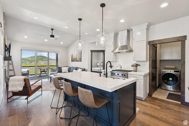 14482 N Buck Horn Trl Unit 50A, Heber City, UT 84032 - kitchen with washer / dryer, wall chimney range hood, open floor plan, decorative backsplash, and white cabinets