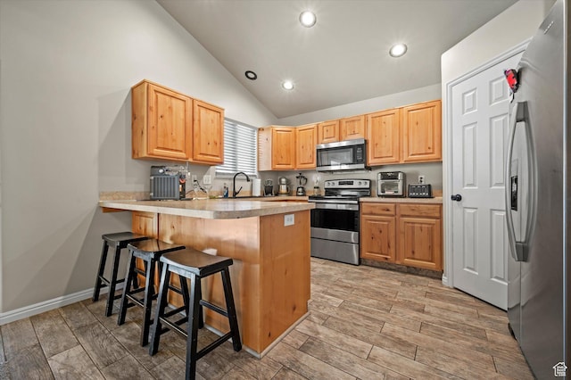 2371 N 1110 W, Clinton, UT 84015 - kitchen featuring appliances with stainless steel finishes, a peninsula, a breakfast bar area, recessed lighting, and light wood finished floors