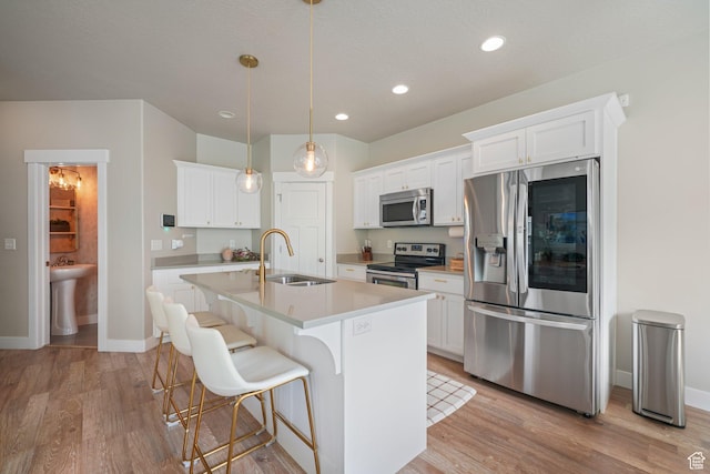 933 S 2100 W, Orem, UT 84059 - kitchen featuring appliances with stainless steel finishes, light wood-type flooring, a kitchen island with sink, white cabinets, and recessed lighting