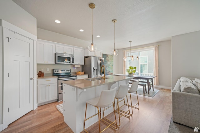 933 S 2100 W, Orem, UT 84059 - kitchen featuring stainless steel appliances, recessed lighting, a kitchen island with sink, white cabinets, and light countertops
