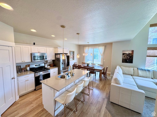 933 S 2100 W, Orem, UT 84059 - kitchen with appliances with stainless steel finishes, healthy amount of natural light, a textured ceiling, light wood-type flooring, and recessed lighting