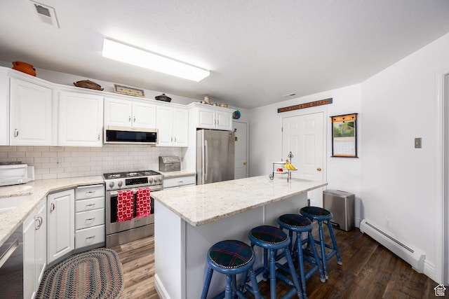 2565 E Woodland Way, Kamas, UT 84036 - kitchen with stainless steel appliances, a baseboard heating unit, dark wood-style floors, and white cabinetry
