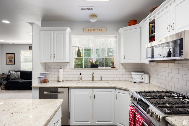 2565 E Woodland Way, Kamas, UT 84036 - kitchen with appliances with stainless steel finishes, white cabinets, tasteful backsplash, light stone counters, and recessed lighting