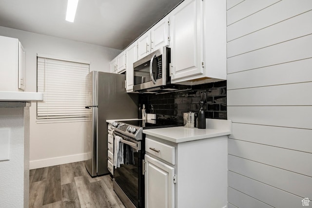 650 S Main St Unit 3102, Bountiful, UT 84010 - kitchen with appliances with stainless steel finishes, backsplash, light wood-style floors, light countertops, and white cabinets