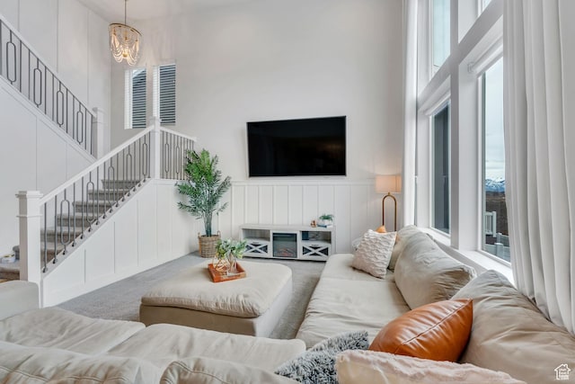 1769 W Stone Gate Dr, Saratoga Springs, UT 84045 - living room featuring a high ceiling, stairway, carpet flooring, a decorative wall, and wainscoting