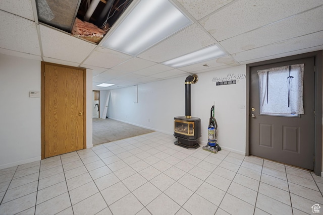 5350 S Jordan Canal Rd, Salt Lake City, UT 84129 - below grade area with a wood stove, a drop ceiling, and light tile patterned floors