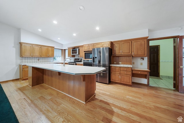 5350 S Jordan Canal Rd, Salt Lake City, UT 84129 - kitchen with stainless steel appliances, light wood finished floors, light countertops, lofted ceiling, and a kitchen island with sink