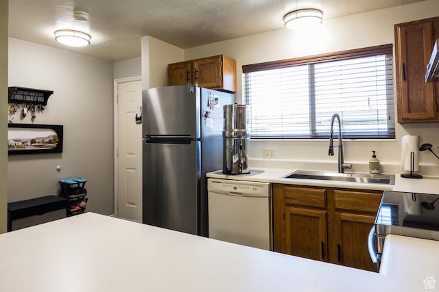 63 S 100 W Unit 17, American Fork, UT 84003 - kitchen featuring freestanding refrigerator, dishwasher, brown cabinetry, and light countertops