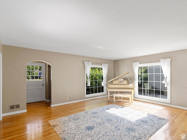 1740 E Harrison Ave, Salt Lake City, UT 84108 - unfurnished living room with arched walkways, healthy amount of natural light, and wood finished floors