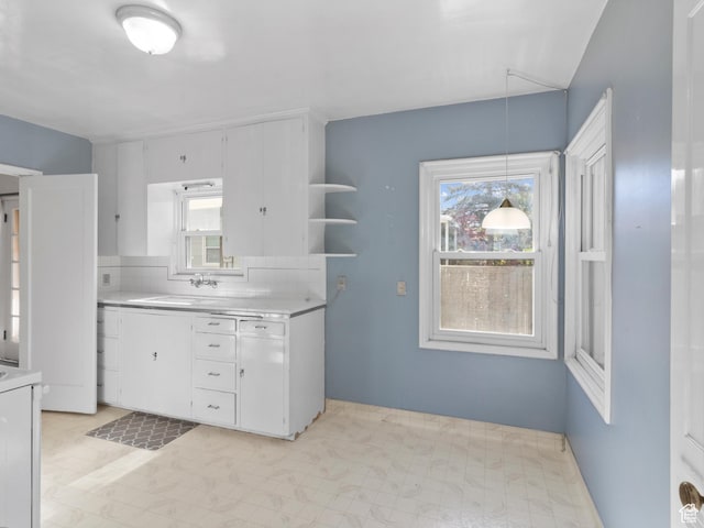 1740 E Harrison Ave, Salt Lake City, UT 84108 - kitchen with light countertops, white cabinetry, and healthy amount of natural light
