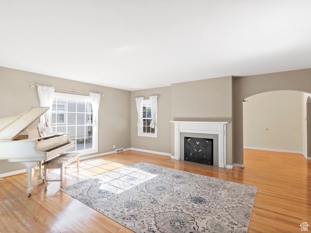 1740 E Harrison Ave, Salt Lake City, UT 84108 - living area with plenty of natural light, arched walkways, wood finished floors, and a fireplace with flush hearth