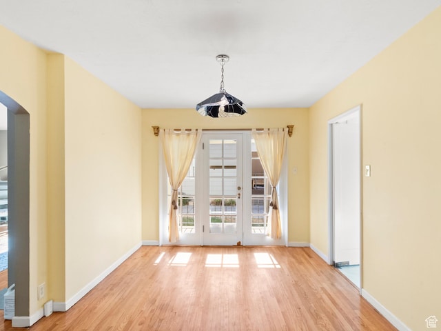 1740 E Harrison Ave, Salt Lake City, UT 84108 - unfurnished dining area with french doors, light wood-style flooring, and arched walkways