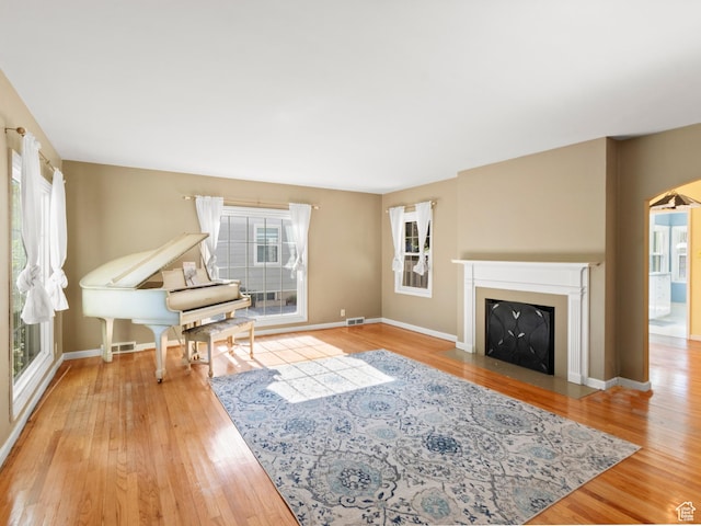 1740 E Harrison Ave, Salt Lake City, UT 84108 - living area with wood finished floors, a fireplace with flush hearth, and arched walkways
