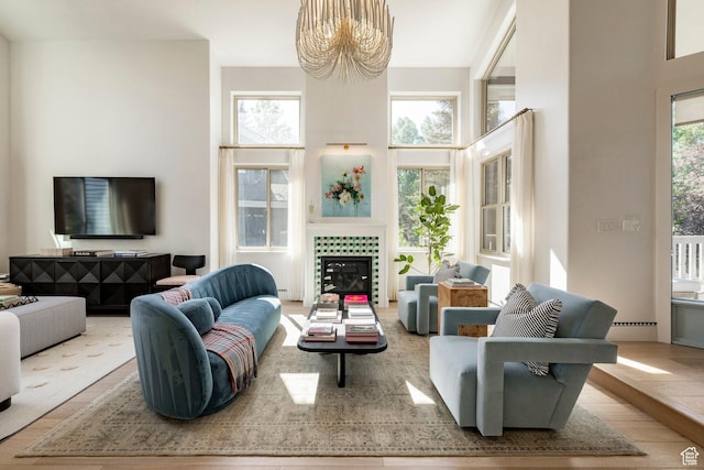 1675 W Silver Springs Rd, Park City, UT 84098 - living area featuring a chandelier, a high ceiling, a tile fireplace, and wood finished floors