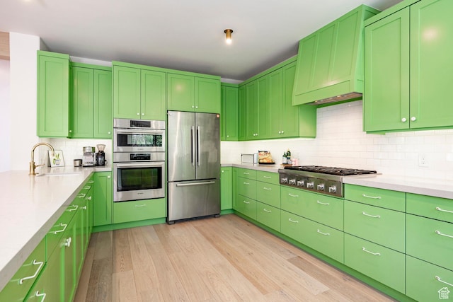 1675 W Silver Springs Rd, Park City, UT 84098 - kitchen with appliances with stainless steel finishes, light wood finished floors, tasteful backsplash, and light countertops