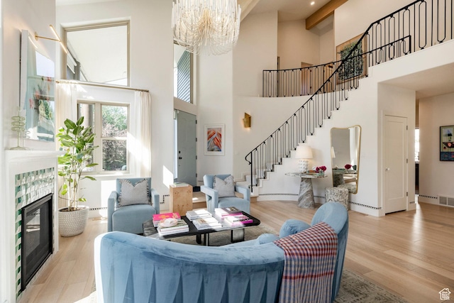 1675 W Silver Springs Rd, Park City, UT 84098 - living area featuring stairway, a chandelier, light wood-style flooring, a high ceiling, and a tiled fireplace