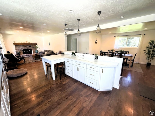 1990 E 400 N, Mapleton, UT 84664 - kitchen featuring a textured ceiling, a breakfast bar, open floor plan, white cabinets, and dark wood-style flooring