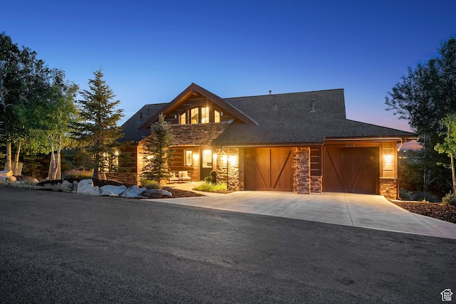 9388 Dye Cabins Dr, Park City, UT 84098 - view of front of house with stone siding, concrete driveway, an attached garage, and roof with shingles