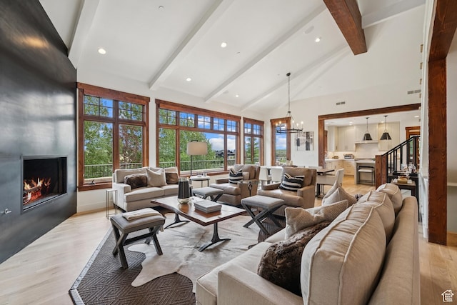 9388 Dye Cabins Dr, Park City, UT 84098 - living room featuring beam ceiling, a fireplace, a chandelier, light wood finished floors, and high vaulted ceiling