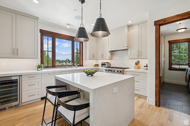 9388 Dye Cabins Dr, Park City, UT 84098 - kitchen featuring beverage cooler, a kitchen island, range, recessed lighting, and a breakfast bar area