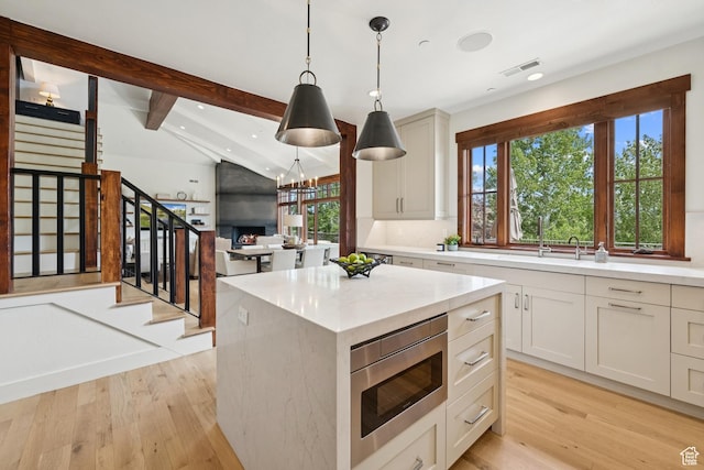 9388 Dye Cabins Dr, Park City, UT 84098 - kitchen with stainless steel microwave, light wood-style floors, pendant lighting, recessed lighting, and a kitchen island