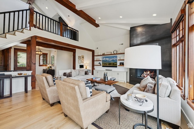 9388 Dye Cabins Dr, Park City, UT 84098 - living room featuring light wood finished floors, a lit fireplace, beam ceiling, recessed lighting, and stairs