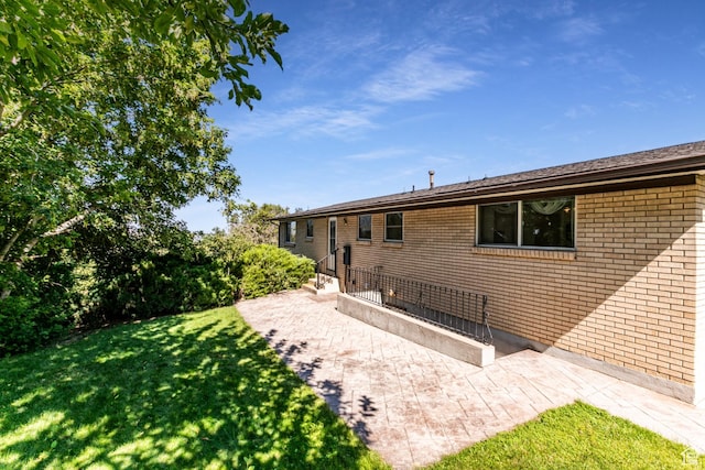 342 E State St, Farmington, UT 84025 - rear view of property with a lawn, brick siding, and a patio area