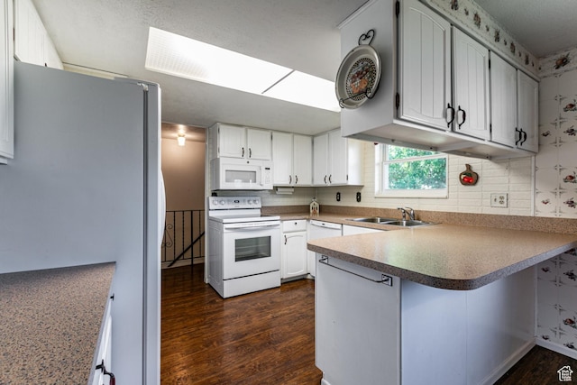 342 E State St, Farmington, UT 84025 - kitchen with white appliances, a peninsula, dark wood finished floors, decorative backsplash, and white cabinets