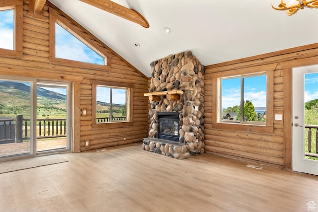 1538 N Mackinaw Way, Garden City, UT 84028 - unfurnished living room with log walls, wood finished floors, high vaulted ceiling, a stone fireplace, and beam ceiling
