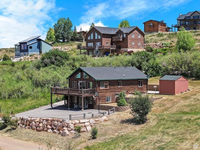 1538 N Mackinaw Way, Garden City, UT 84028 - rear view of house with a deck, a patio, a shed, and log siding