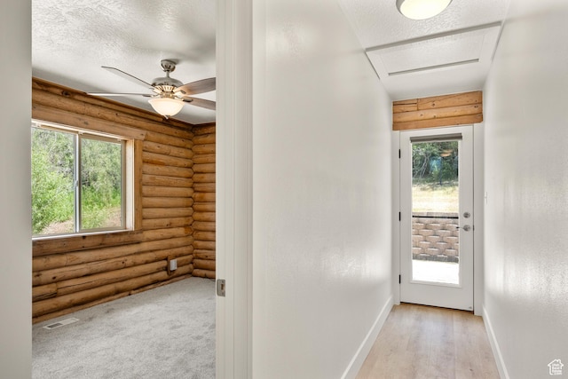 1538 N Mackinaw Way, Garden City, UT 84028 - hall featuring rustic walls, plenty of natural light, light wood-style flooring, and a textured ceiling
