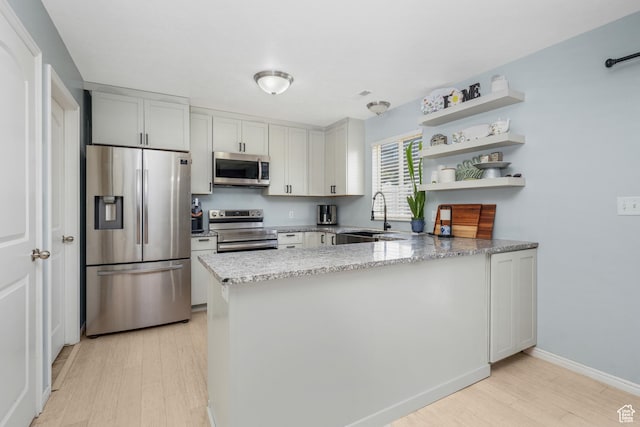 1244 E 800 N Unit 43, Spanish Fork, UT 84660 - kitchen with appliances with stainless steel finishes, light wood-type flooring, a peninsula, light stone countertops, and open shelves