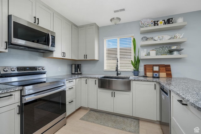 1244 E 800 N Unit 43, Spanish Fork, UT 84660 - kitchen with stainless steel appliances, light wood finished floors, light stone counters, and open shelves