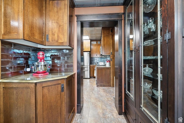 367 W 400 N, Malad City, ID 83252 - kitchen featuring brown cabinets, decorative backsplash, light countertops, and freestanding refrigerator