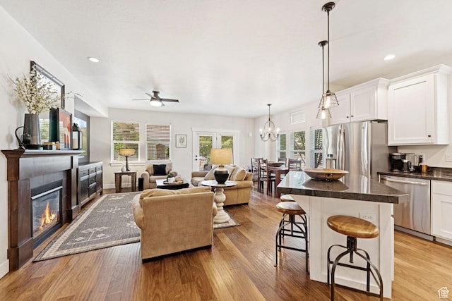 693 S Silver Leaf Dr W, Mapleton, UT 84664 - living room with a ceiling fan, light wood-type flooring, a glass covered fireplace, plenty of natural light, and recessed lighting