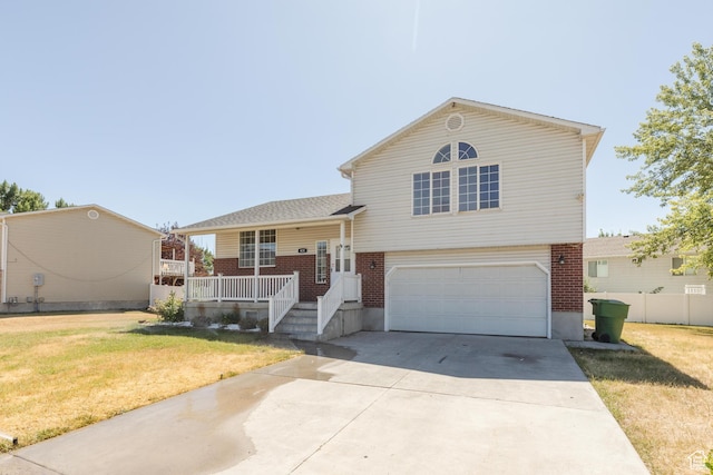431 S Oakwood Dr W, Logan, UT 84321 - tri-level home with brick siding, an attached garage, concrete driveway, and a front lawn