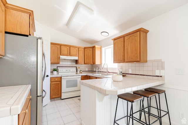 431 S Oakwood Dr W, Logan, UT 84321 - kitchen with white electric range, freestanding refrigerator, a peninsula, under cabinet range hood, and lofted ceiling