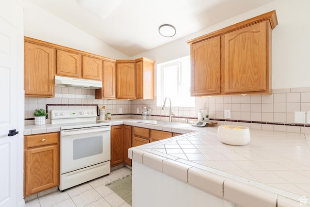 431 S Oakwood Dr W, Logan, UT 84321 - kitchen with white electric range oven, under cabinet range hood, tile counters, tasteful backsplash, and lofted ceiling