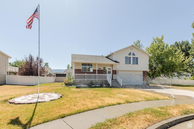 431 S Oakwood Dr W, Logan, UT 84321 - tri-level home featuring a porch, brick siding, a garage, and driveway