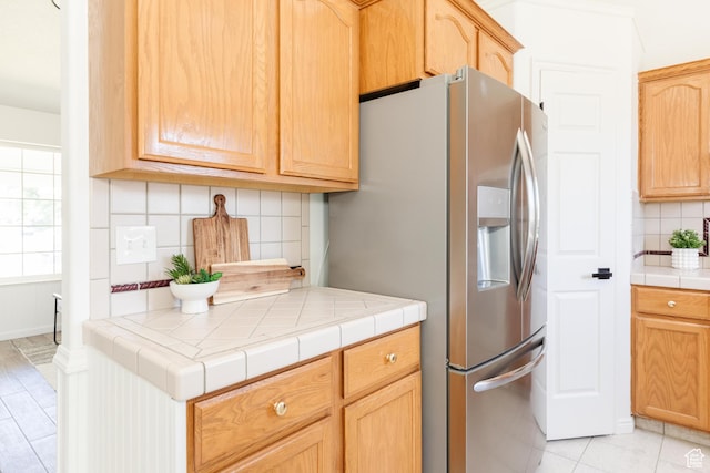 431 S Oakwood Dr W, Logan, UT 84321 - kitchen with stainless steel fridge with ice dispenser, backsplash, tile countertops, and light brown cabinets