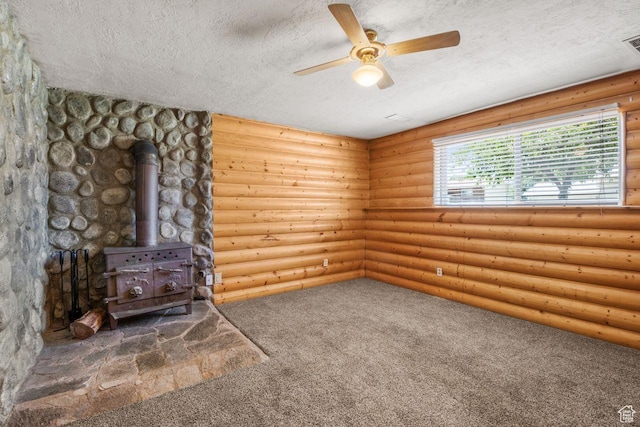 5062 S 2875 W, Roy, UT 84067 - carpeted empty room featuring a wood stove, a textured ceiling, ceiling fan, and rustic walls