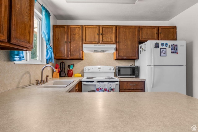 5062 S 2875 W, Roy, UT 84067 - kitchen featuring white appliances, under cabinet range hood, light countertops, and brown cabinets