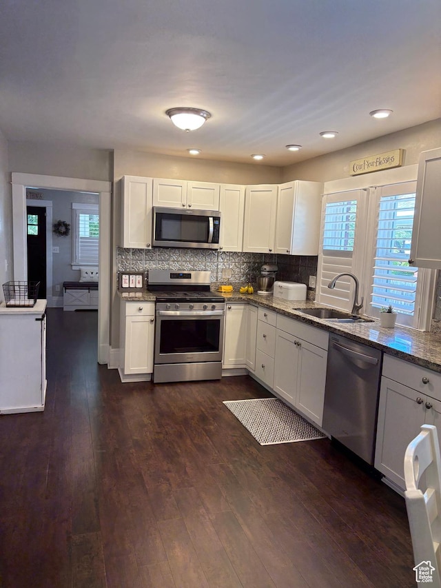 2044 Madison Ave, Ogden, UT 84401 - kitchen featuring appliances with stainless steel finishes, stone counters, dark wood-type flooring, decorative backsplash, and white cabinets