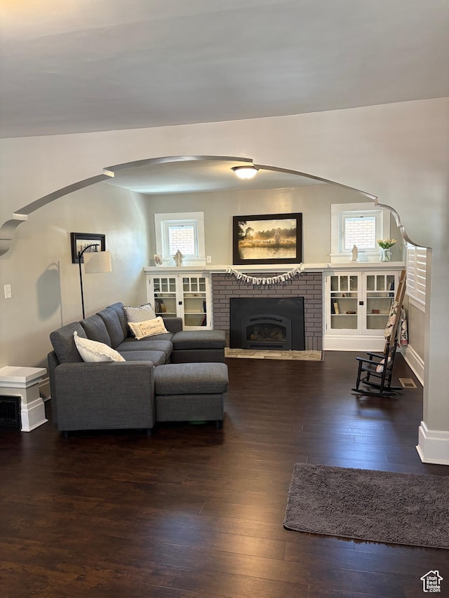 2044 Madison Ave, Ogden, UT 84401 - living area featuring hardwood / wood-style flooring, arched walkways, and a brick fireplace