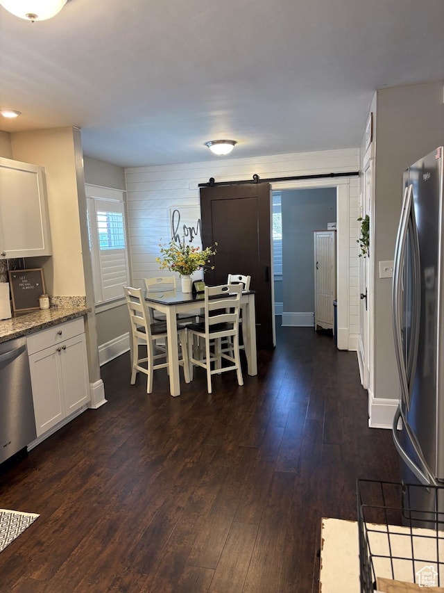 2044 Madison Ave, Ogden, UT 84401 - dining space featuring a barn door and dark wood-style flooring