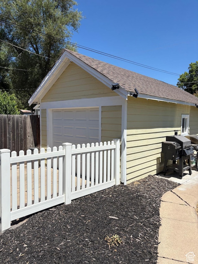 2044 Madison Ave, Ogden, UT 84401 - view of side of home featuring an outdoor structure, roof with shingles, and a detached garage