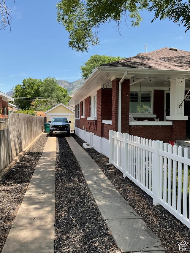2044 Madison Ave, Ogden, UT 84401 - view of property exterior featuring brick siding, driveway, a mountain view, roof with shingles, and a detached garage