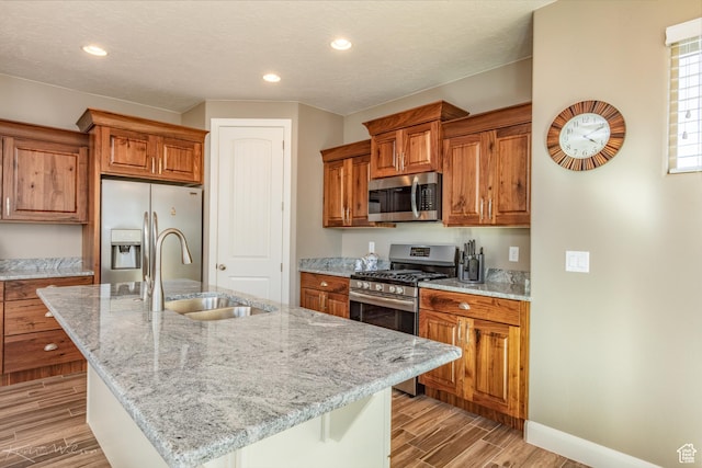 3429 W 175 N, Hurricane, UT 84737 - kitchen with appliances with stainless steel finishes, brown cabinets, light wood-style floors, light stone counters, and recessed lighting