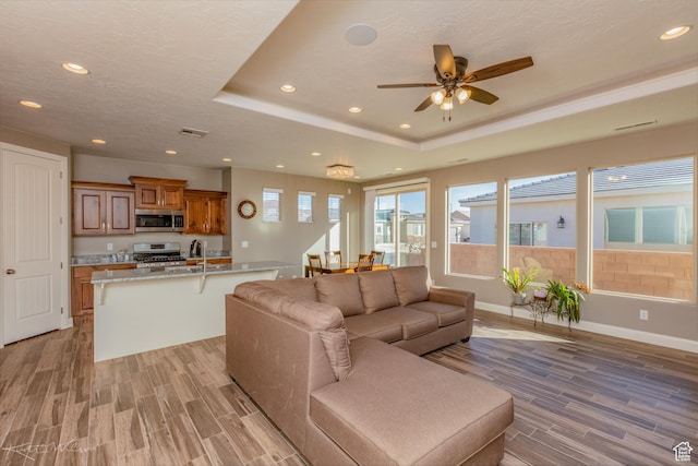 3429 W 175 N, Hurricane, UT 84737 - living room featuring light wood-style floors, a raised ceiling, recessed lighting, and a ceiling fan